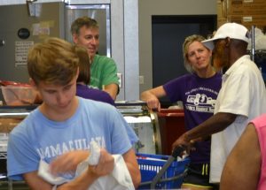 Brian and Elyse from Farmers Against Hunger hosting a tasting during a busy day at the East Hanover Street Pantry.