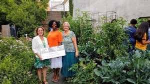 With our bountiful community garden as a summertime backdrop, Arm in Arm's Carolyn Biondi with UWGMC's Sandra Toussaint and Tarry Truitt.